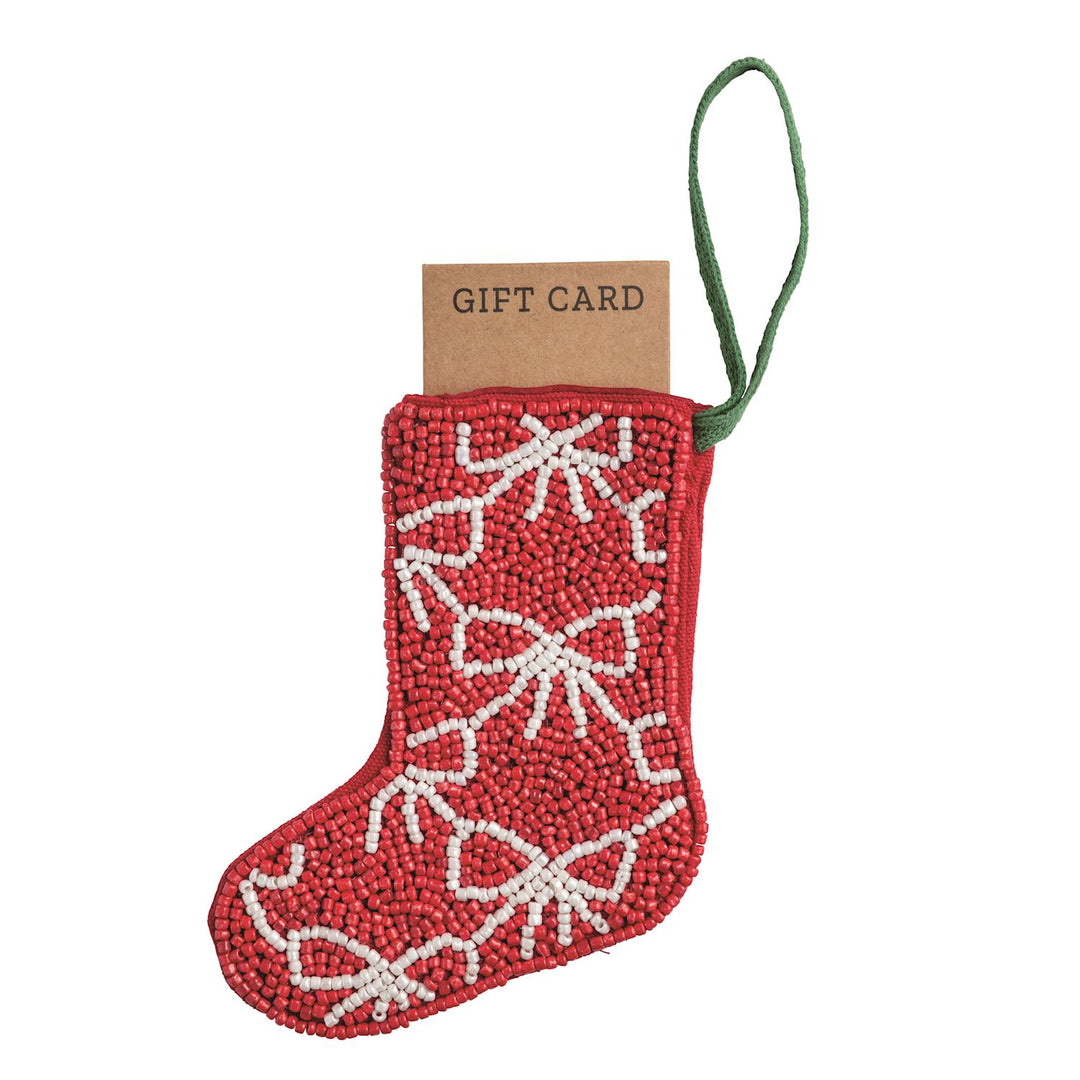 Red beaded stocking ornament with white snowflake pattern and green loop, holding a gift card.